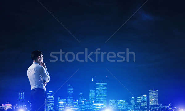 Businessman viewing night glowing city Stock photo © adam121
