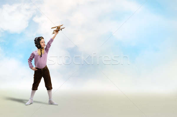 girl in helmet pilot playing with a toy airplane Stock photo © adam121