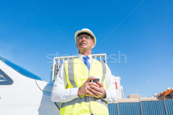 Engineer builder on construction site at sunny day with coffee in hand Stock photo © adam121