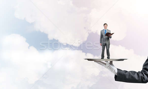 Businessman on metal tray with red book in hands against blue sky background Stock photo © adam121