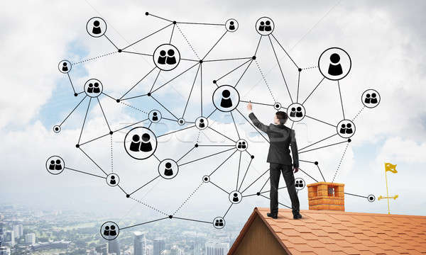 Businessman on house roof presenting networking and connection concept. Mixed media Stock photo © adam121