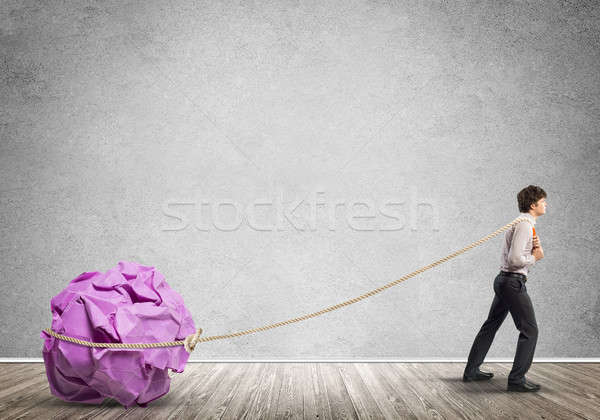 Man pulling with effort big crumpled ball of paper as creativity sign Stock photo © adam121