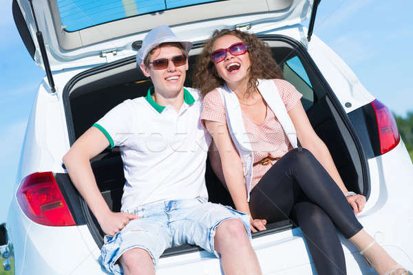 Stock photo: young couple sitting in the open trunk