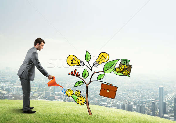 Young businessman outdoors watering drawn growth concept with can Stock photo © adam121