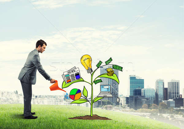 Young businessman outdoors watering drawn growth concept with can Stock photo © adam121