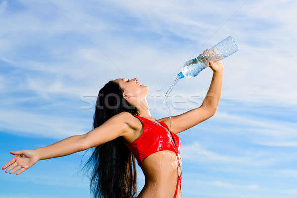 Stock photo: sport girl in red uniform with a bottle of water