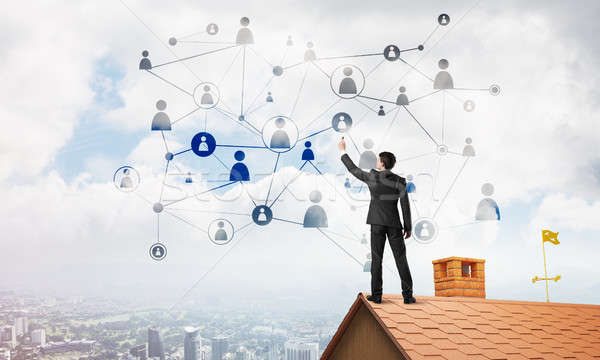 Businessman on house roof presenting networking and connection concept. Mixed media Stock photo © adam121