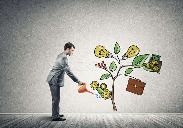 Young businessman in empty room watering drawn growth concept wi Stock photo © adam121