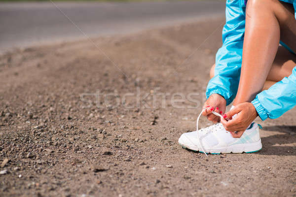 Fiatal nő cipőfűző sportcipők vidéki út testmozgás Stock fotó © adam121
