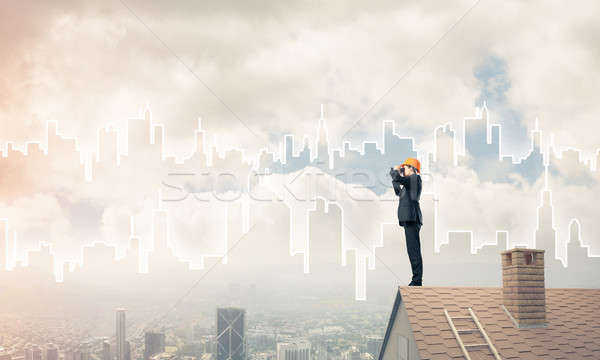 Engineer man standing on roof and looking in binoculars. Mixed m Stock photo © adam121