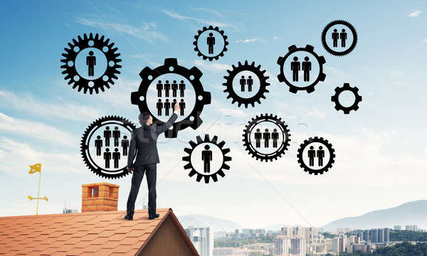 Businessman on house roof presenting teamwork and connection con Stock photo © adam121