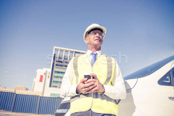 Stock photo: Engineer builder on construction site at sunny day with coffee i