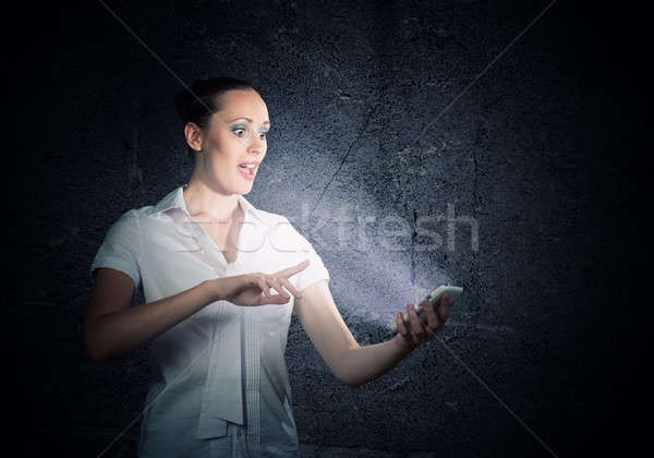 Tineri femeie atragatoare telefon mobil întuneric cameră Imagine de stoc © adam121