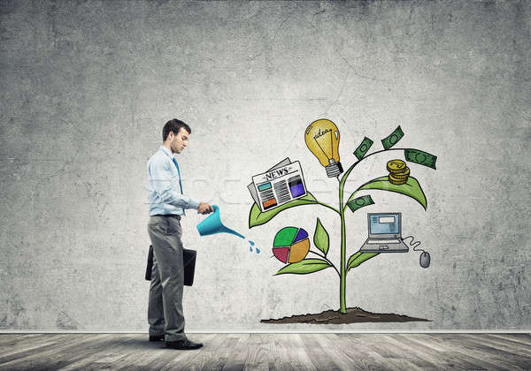 Young businessman in empty room watering drawn growth concept wi Stock photo © adam121