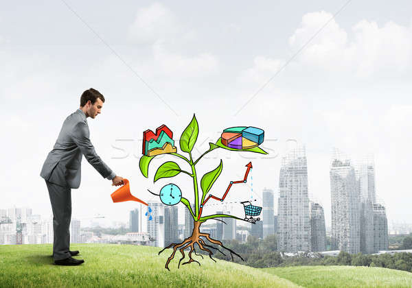 Young businessman outdoors watering drawn growth concept with can Stock photo © adam121