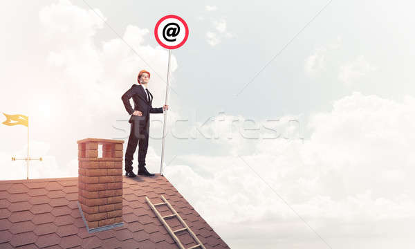 Businessman in suit and helmet presenting email concept on signb Stock photo © adam121