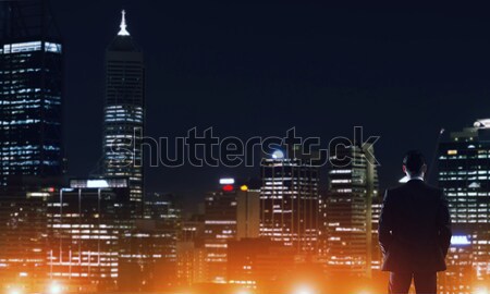 Stock photo: Businessman viewing night glowing city