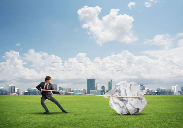 Man pulling with effort big crumpled ball of paper as creativity sign Stock photo © adam121