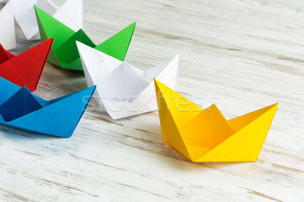 Business leadership concept with white and color paper boats on wooden table Stock photo © adam121