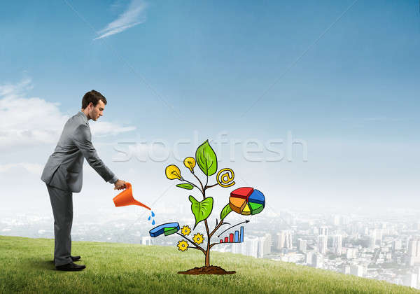 Young businessman outdoors watering drawn growth concept with can Stock photo © adam121