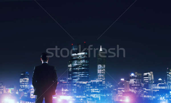 Businessman viewing night glowing city Stock photo © adam121