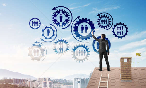 Businessman on house roof presenting teamwork and connection concept. Mixed media Stock photo © adam121