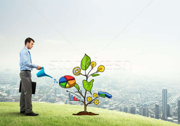 Young businessman outdoors watering drawn growth concept with can Stock photo © adam121