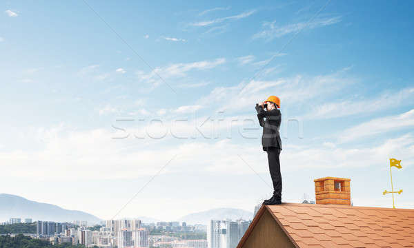 Engineer man standing on roof and looking in binoculars. Mixed media Stock photo © adam121