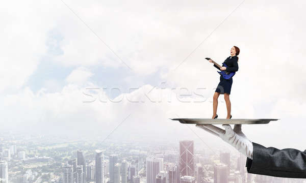 Attractive businesswoman on metal tray playing electric guitar against cityscape background Stock photo © adam121