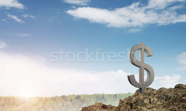 Money making and wealth concept presented by stone dollar symbol on natural landscape Stock photo © adam121