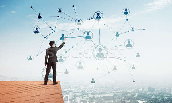 Stock photo: Businessman on house roof presenting networking and connection concept. Mixed media