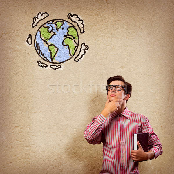 Stock photo: young man with a book thinks