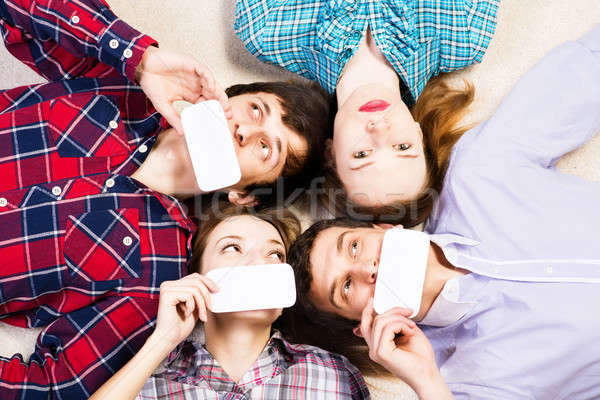 Quatro jovens mentir juntos cara cartão em branco Foto stock © adam121