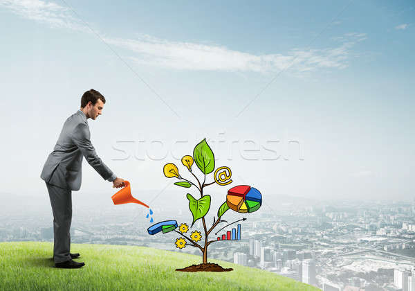 Young businessman outdoors watering drawn growth concept with can Stock photo © adam121