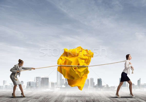 Two women pulling with effort big crumpled ball of paper as creativity sign Stock photo © adam121