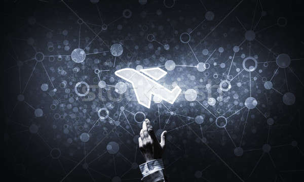 Airplane glowing icon touched with finger as online booking conc Stock photo © adam121