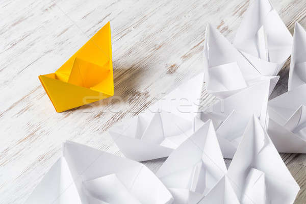 Business leadership concept with white and color paper boats on wooden table Stock photo © adam121