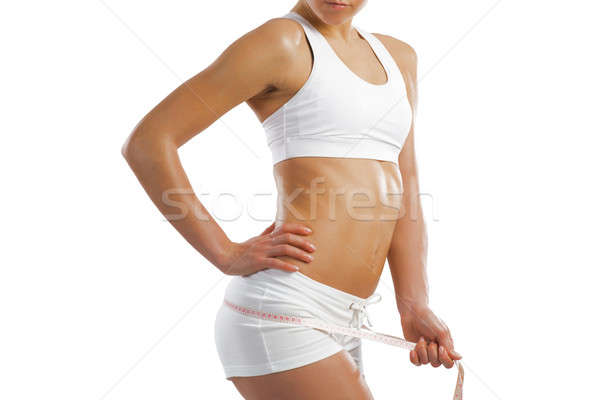 Stock photo: young athletic woman measuring waist