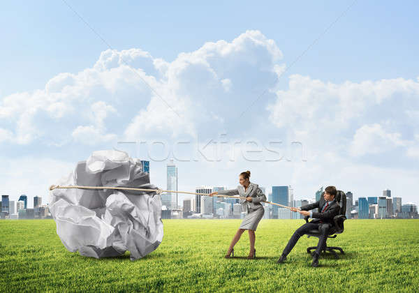 Businesspeople pulling with effort big crumpled ball of paper as creativity sign Stock photo © adam121
