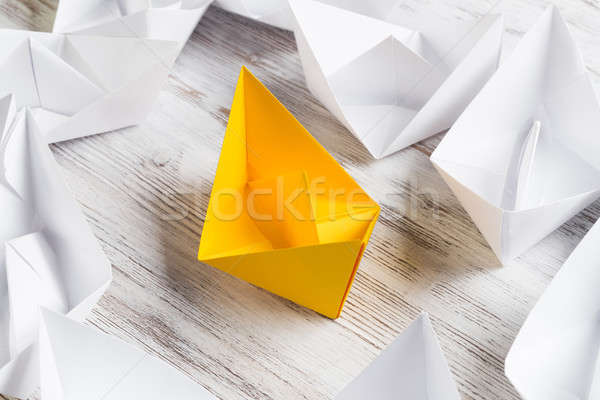 Stock photo: Business leadership concept with white and color paper boats on wooden table
