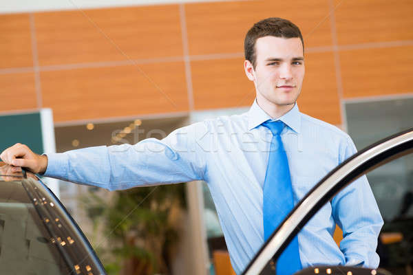 dealer stands near a new car in the showroom Stock photo © adam121
