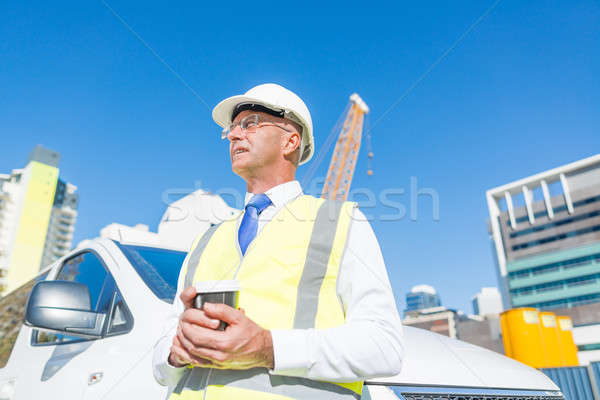 Engineer builder on construction site at sunny day with coffee in hand Stock photo © adam121