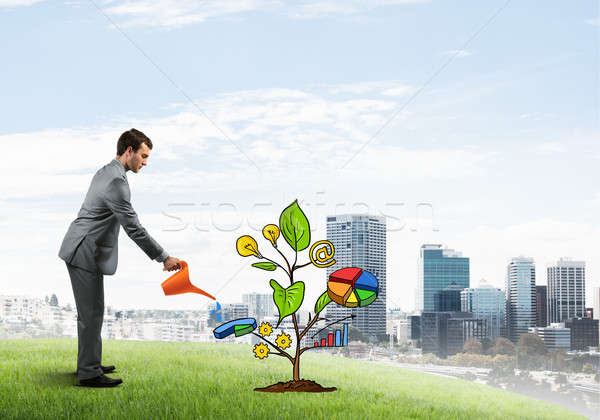 Young businessman outdoors watering drawn growth concept with can Stock photo © adam121