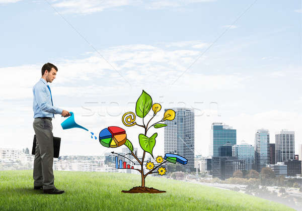Young businessman outdoors watering drawn growth concept with can Stock photo © adam121