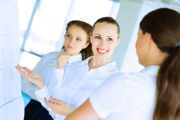 Stock photo: businessmen are meeting near the flipchart