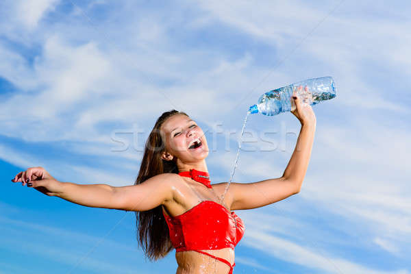Stock photo: sport girl in red uniform with a bottle of water