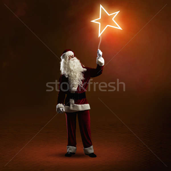 Santa Claus is holding a shining star Stock photo © adam121