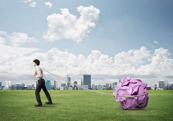 Stock photo: Man pulling with effort big crumpled ball of paper as creativity
