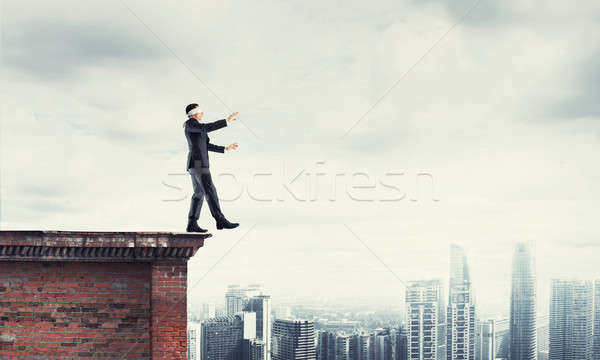 Stock photo: Danger and risk concept with businessman making step from edge
