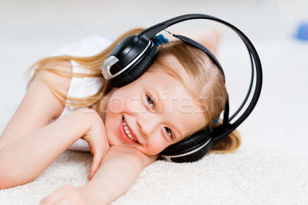 Pretty girl listening to music on headphones Stock photo © adam121
